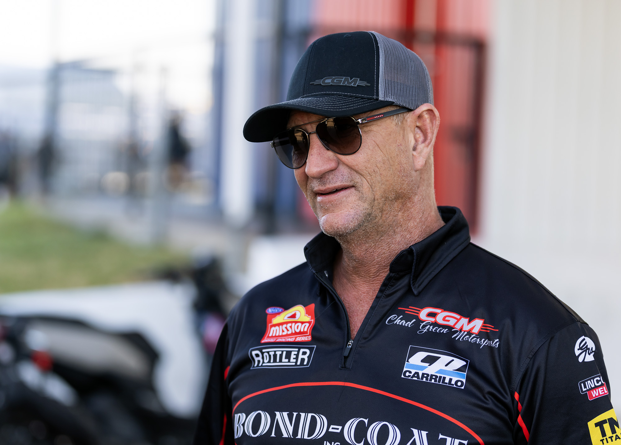 Chad Green in a CGM cap, smiling in the pits