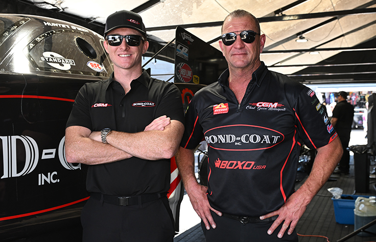 Hunter and Chad Green standing side by side in the pit area in front of the Bond-Coat Funny Car